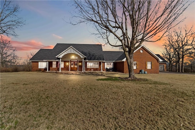 view of front of house with brick siding and a front lawn