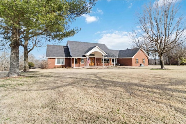 view of front of property with a front lawn, a porch, and brick siding