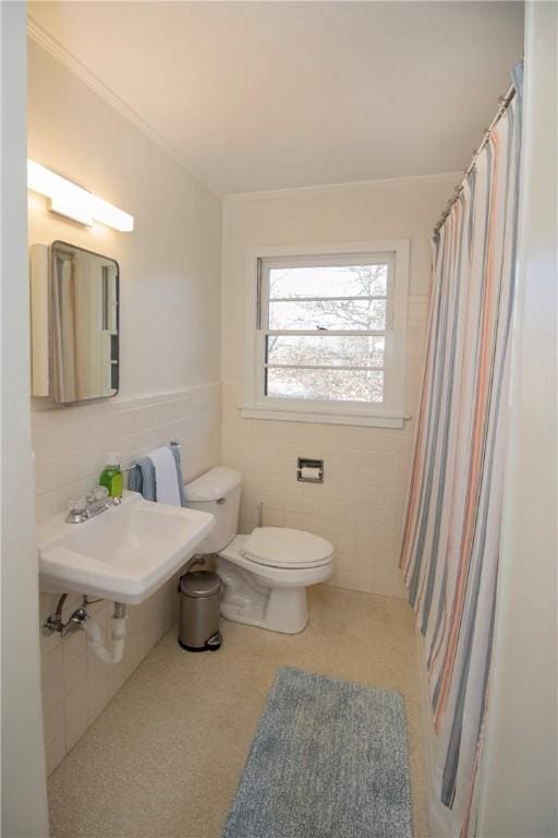 bathroom with a sink, toilet, tile walls, and crown molding