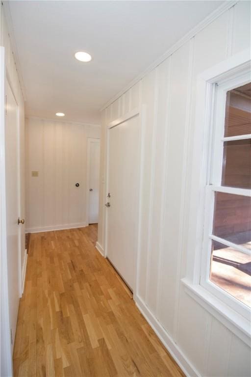 corridor with a decorative wall, recessed lighting, and light wood finished floors