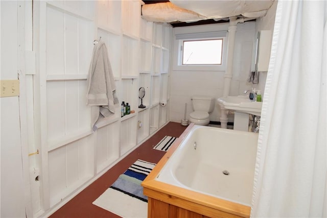 full bathroom with toilet and a tub to relax in