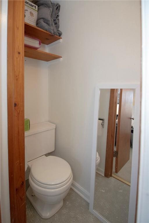 bathroom with toilet and baseboards