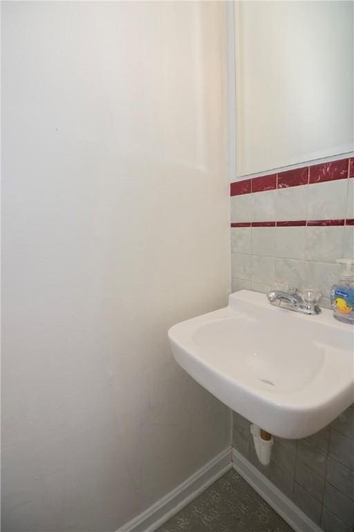 bathroom with tile walls, baseboards, and a sink