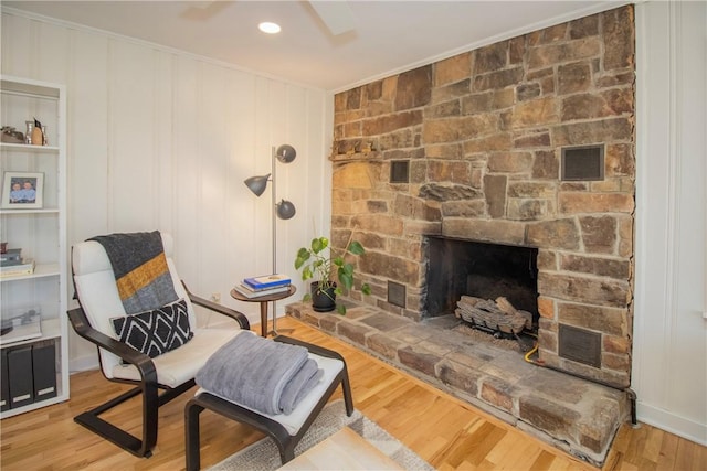 sitting room featuring a fireplace, light wood-style floors, and ornamental molding