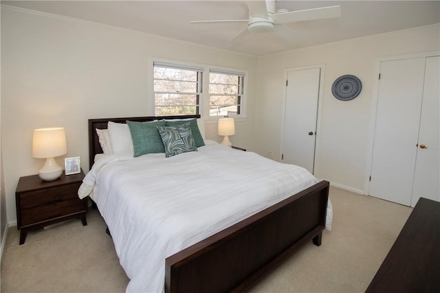 bedroom featuring light colored carpet and a ceiling fan