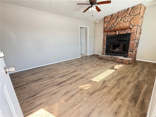 unfurnished living room featuring a textured ceiling, a fireplace, and wood finished floors