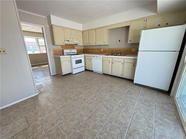 kitchen featuring cream cabinets, under cabinet range hood, white appliances, a sink, and light countertops