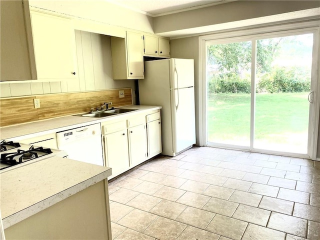 kitchen with light countertops, white appliances, a sink, and a healthy amount of sunlight