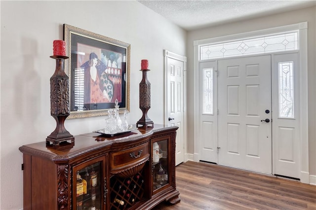 entrance foyer featuring a textured ceiling and wood finished floors