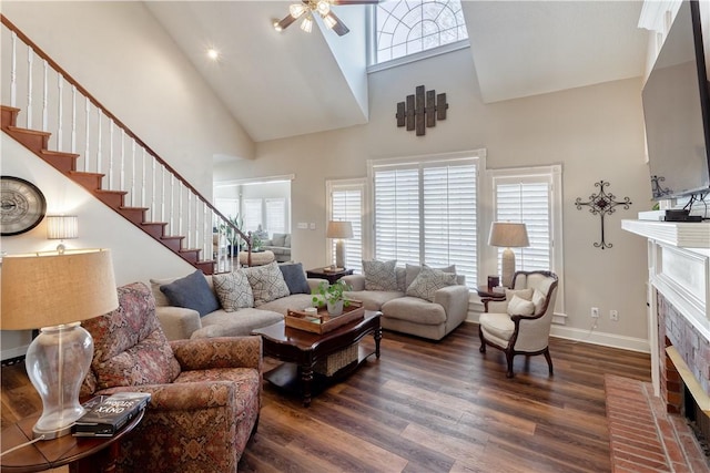 living area with a high ceiling, a fireplace, wood finished floors, baseboards, and stairs