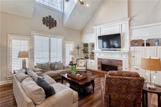 living room with high vaulted ceiling, dark wood-style flooring, a brick fireplace, and a ceiling fan