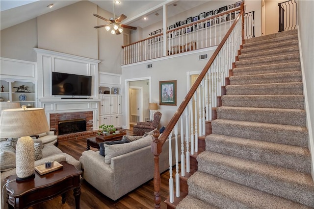 living room with dark wood-style floors, visible vents, and stairway