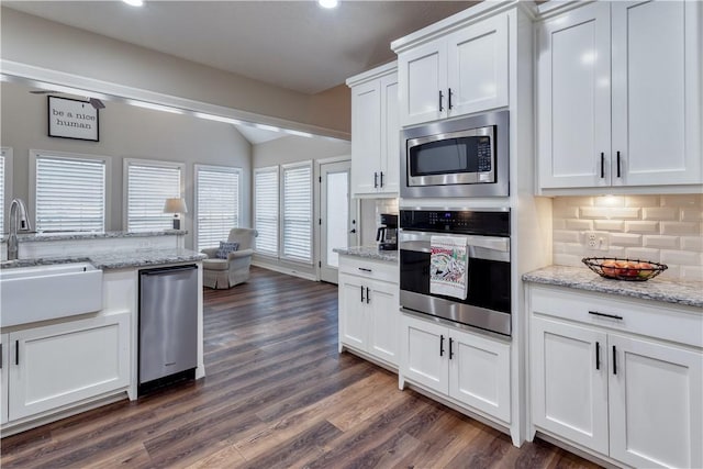 kitchen featuring white cabinets, dark wood finished floors, stainless steel appliances, and a sink