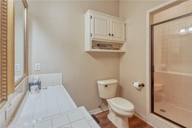 full bath with baseboards, a shower stall, toilet, and wood finished floors