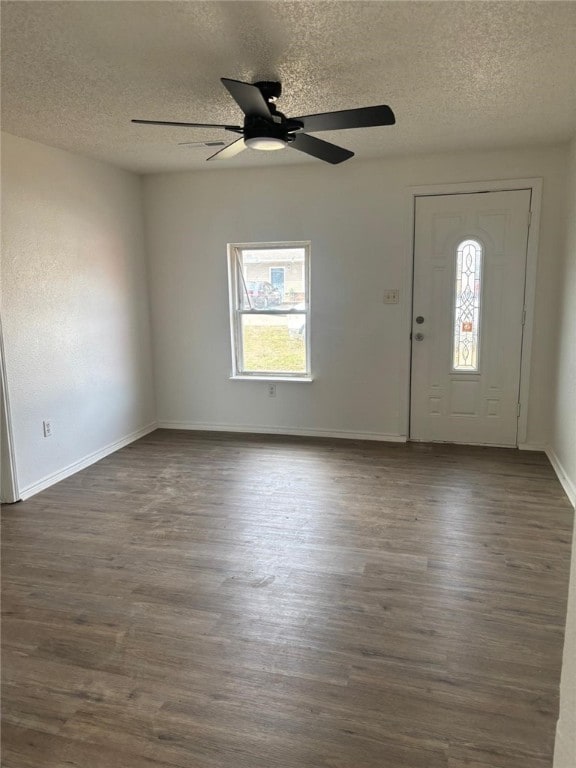 foyer entrance with baseboards, dark wood finished floors, and a textured ceiling