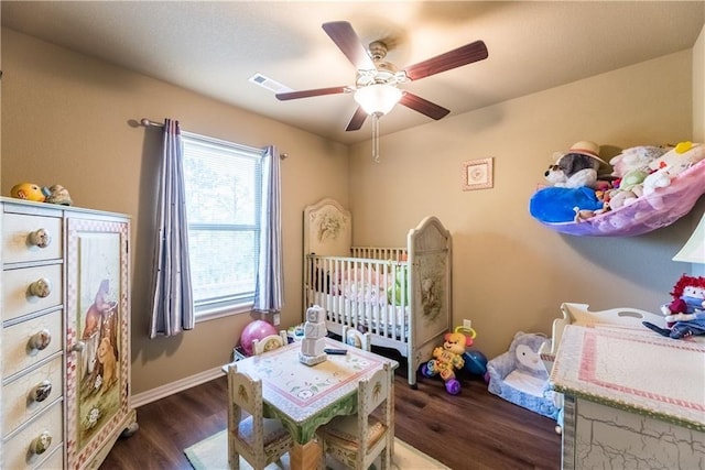 bedroom with dark wood-style flooring, visible vents, ceiling fan, and baseboards