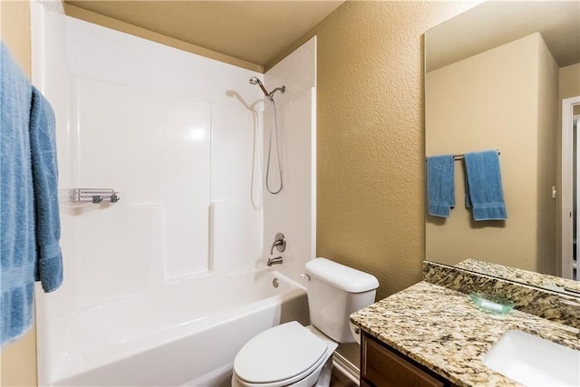 full bathroom featuring toilet, vanity, bathtub / shower combination, and a textured wall