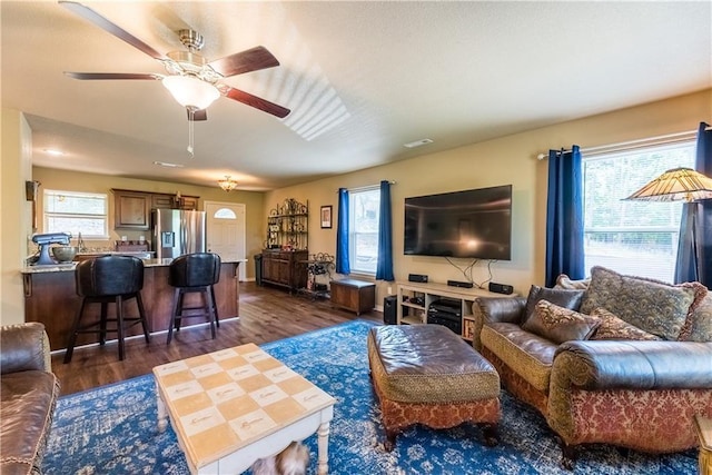 living area featuring dark wood-style floors, ceiling fan, and visible vents