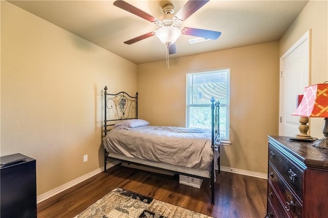 bedroom with dark wood-type flooring, ceiling fan, and baseboards