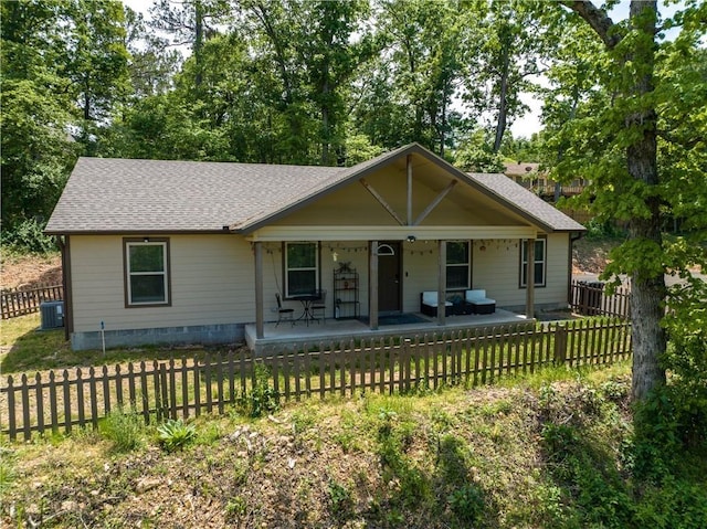 view of front of house featuring a shingled roof, a fenced front yard, crawl space, covered porch, and central air condition unit