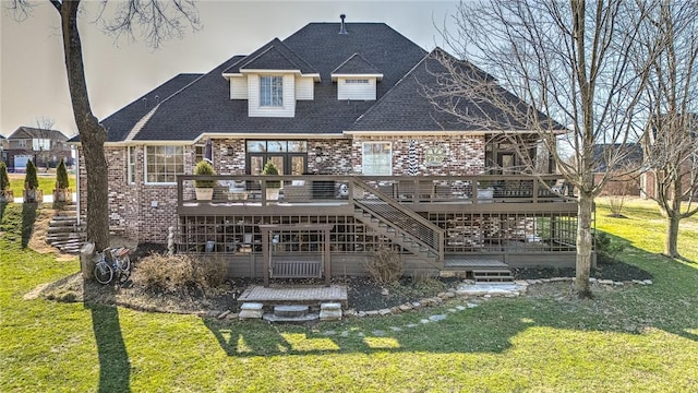 rear view of house with stairway, a lawn, a deck, and brick siding