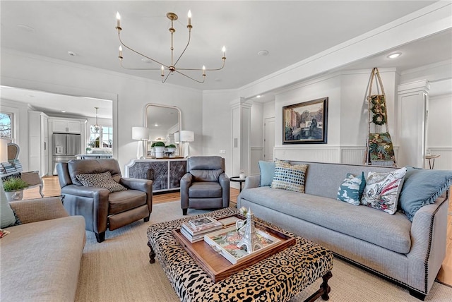 living area with a chandelier, crown molding, and ornate columns