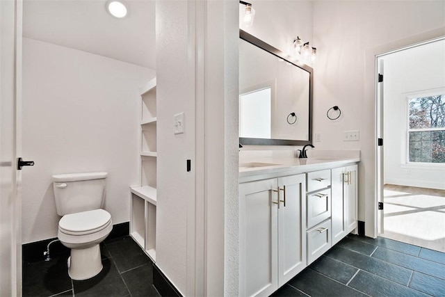 bathroom featuring vanity, tile patterned floors, toilet, and baseboards