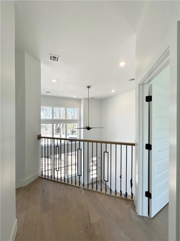 hall featuring visible vents, recessed lighting, baseboards, and wood finished floors