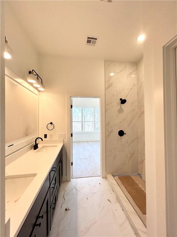 full bathroom featuring a marble finish shower, visible vents, marble finish floor, and a sink