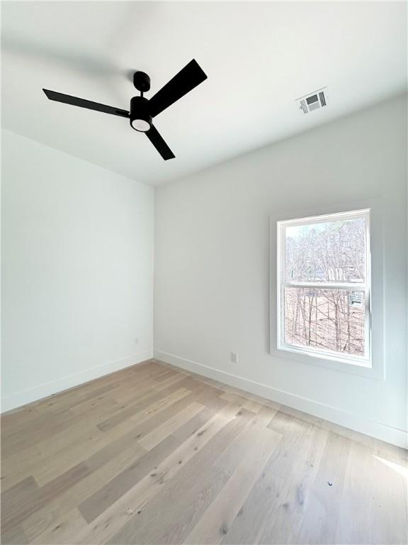 unfurnished room featuring visible vents, baseboards, light wood-type flooring, and ceiling fan