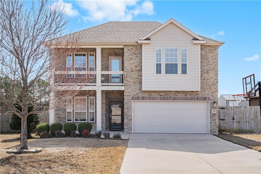 505 Hampton Park Bnd, Cave Springs, AR 72718 - view of front of house with an attached garage, a balcony, fence, driveway, and stone siding