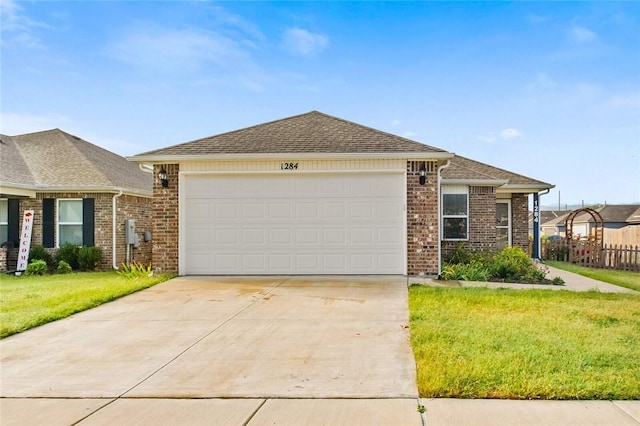 ranch-style home featuring a garage, concrete driveway, fence, a front yard, and brick siding