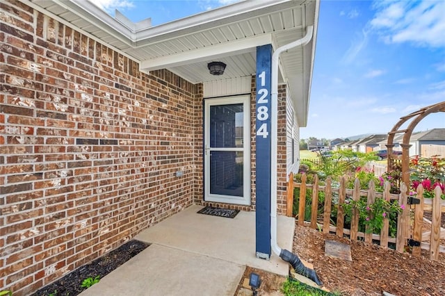 view of exterior entry with brick siding