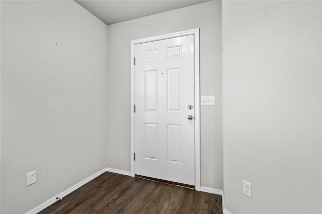 doorway featuring dark wood finished floors and baseboards