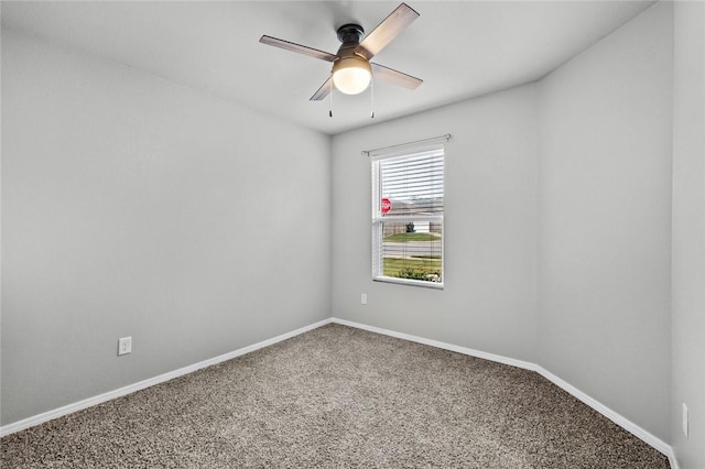 carpeted spare room with ceiling fan and baseboards