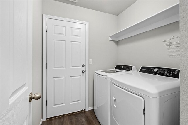 washroom featuring laundry area, washer and clothes dryer, dark wood finished floors, and baseboards