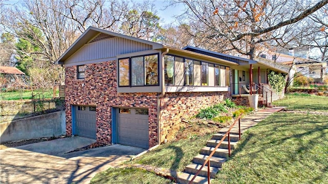 view of side of property featuring a garage, a lawn, brick siding, and driveway