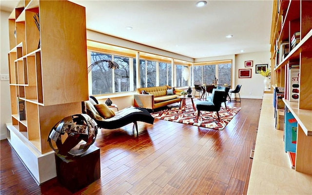 living area featuring recessed lighting, baseboards, and wood finished floors