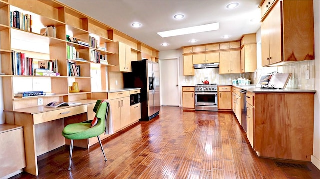 kitchen featuring light brown cabinets, under cabinet range hood, decorative backsplash, appliances with stainless steel finishes, and dark wood-style flooring