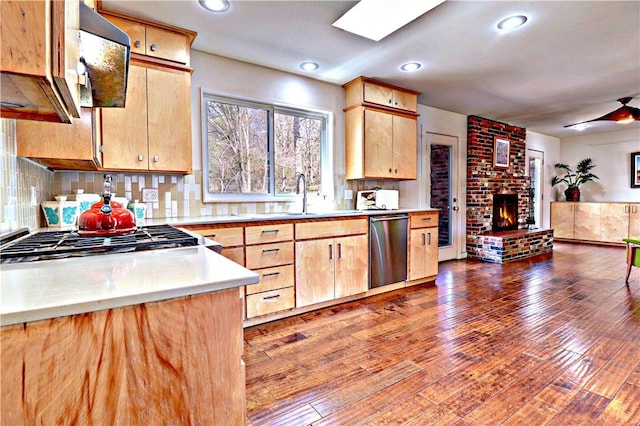 kitchen featuring backsplash, a brick fireplace, light countertops, hardwood / wood-style floors, and stainless steel appliances