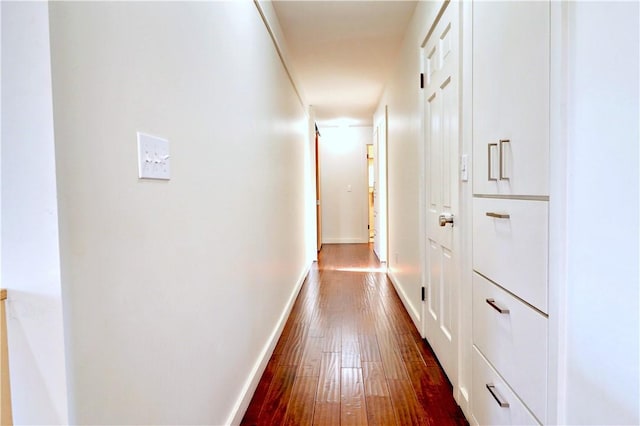 hall with baseboards and dark wood-type flooring