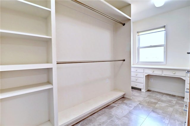 spacious closet featuring built in desk