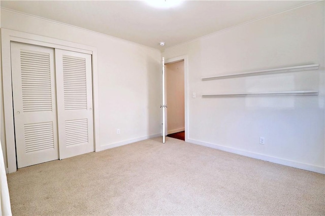 unfurnished bedroom featuring baseboards, carpet, a closet, and ornamental molding