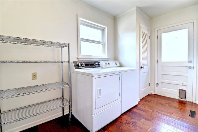 laundry area featuring visible vents, dark wood-type flooring, washer and clothes dryer, crown molding, and laundry area