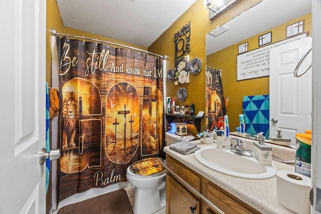 bathroom with a textured ceiling, vanity, and toilet