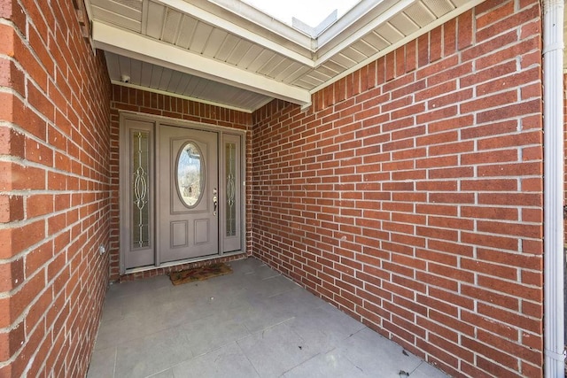 view of exterior entry with brick siding