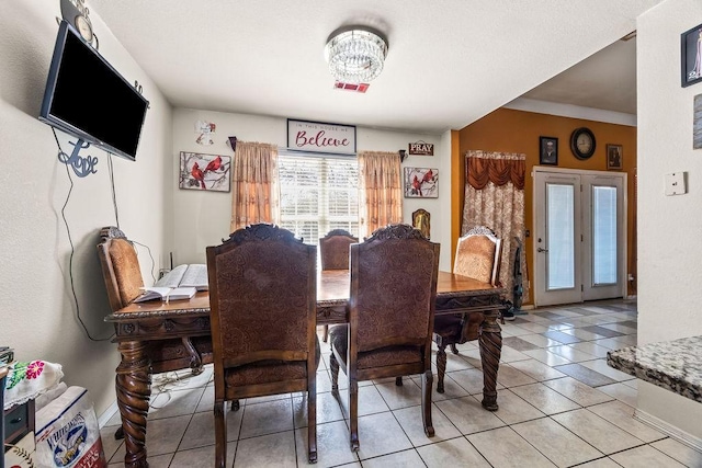 dining space with french doors and light tile patterned floors