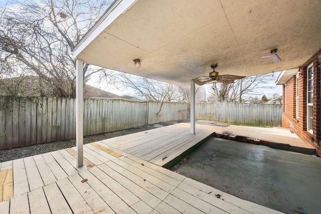 wooden deck with a ceiling fan, a fenced backyard, and a patio