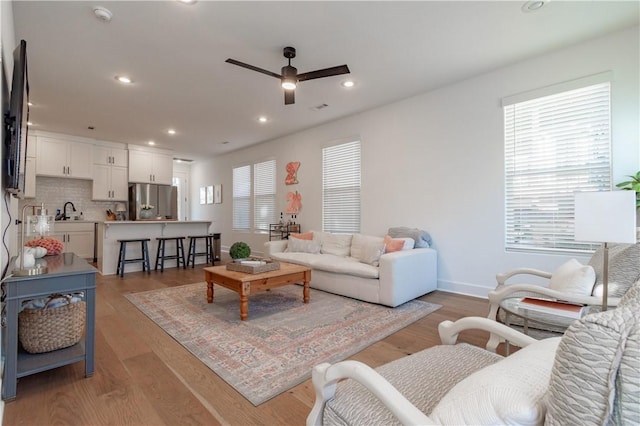 living area featuring a wealth of natural light, light wood-style flooring, and recessed lighting