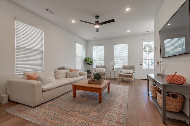 living area featuring a healthy amount of sunlight, visible vents, wood finished floors, and recessed lighting